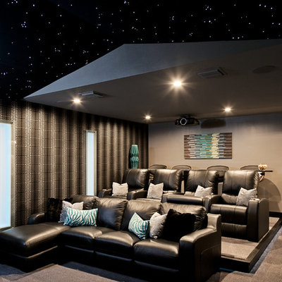 Inspiration for a large contemporary enclosed carpeted and beige floor home theater remodel in Orlando with a projector screen and gray walls