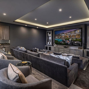 Inspiration for a mediterranean enclosed carpeted and brown floor home theater remodel in Orange County with gray walls and a projector screen