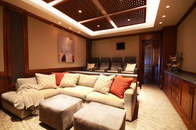 Large trendy enclosed carpeted home theater photo in Los Angeles with gray walls and a projector screen