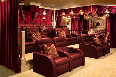 Foto de cine en casa cerrado clásico grande con paredes rojas, moqueta y pantalla de proyección