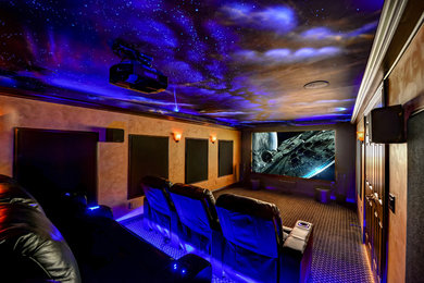 Imagen de cine en casa abierto clásico renovado grande con paredes grises, moqueta y pantalla de proyección