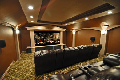 Example of a trendy carpeted home theater design in Dallas with brown walls and a media wall