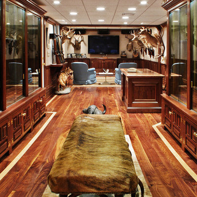 Home theater - large rustic enclosed light wood floor home theater idea in New York with beige walls and a wall-mounted tv