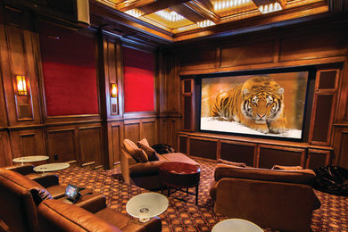 Modelo de cine en casa cerrado extra grande con paredes marrones, moqueta, pantalla de proyección y suelo multicolor