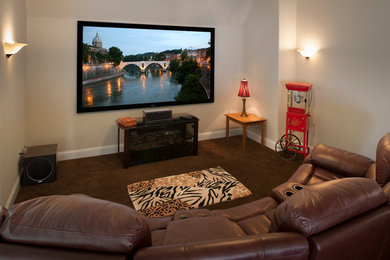 Diseño de cine en casa cerrado contemporáneo con paredes beige, moqueta, televisor colgado en la pared y suelo marrón