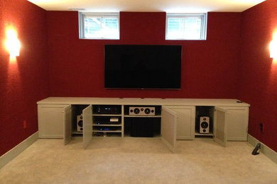 This is an example of a home cinema in Boston with red walls, carpet and a wall mounted tv.