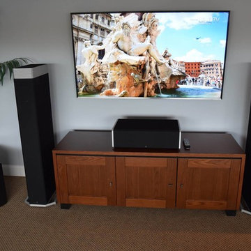 Flat Panel UHD TV Mounted w/ Floorstanding Speakers, Center Channel & AV Cabinet