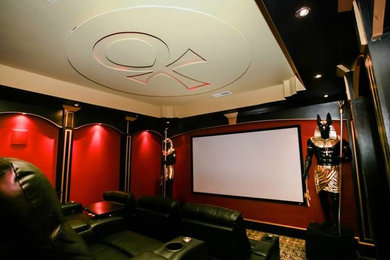 Diseño de cine en casa tradicional con paredes rojas, moqueta y pantalla de proyección