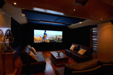 Imagen de cine en casa cerrado contemporáneo grande con paredes beige, pantalla de proyección, suelo de madera oscura y suelo marrón