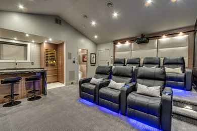 Inspiration for a large contemporary open concept carpeted home theater remodel in Vancouver with gray walls and a projector screen