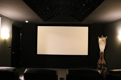 Ejemplo de cine en casa cerrado contemporáneo pequeño con paredes grises, moqueta y pantalla de proyección
