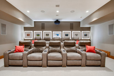 Inspiration for a large contemporary enclosed carpeted home theater remodel in New York with a projector screen