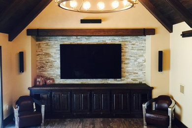 This is an example of a medium sized rustic open plan home cinema in Orlando with beige walls, dark hardwood flooring and a built-in media unit.