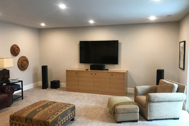 Inspiration for a mid-sized contemporary enclosed carpeted and beige floor home theater remodel in Salt Lake City with a wall-mounted tv and beige walls