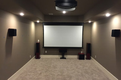 This is an example of a traditional home cinema in Atlanta with beige walls, concrete flooring and beige floors.