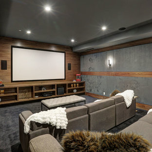 Esempio di un grande home theatre contemporaneo chiuso con pareti grigie, moquette, TV a parete e pavimento nero