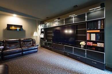 Mid-sized minimalist enclosed carpeted and black floor home theater photo in Houston with gray walls and a wall-mounted tv