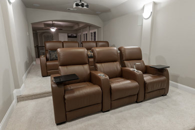 Modelo de cine en casa abierto moderno de tamaño medio con paredes grises, moqueta, pantalla de proyección y suelo blanco