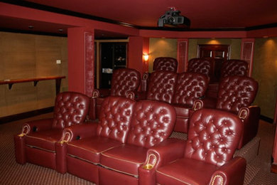 Modelo de cine en casa abierto grande con paredes rojas, moqueta y pantalla de proyección