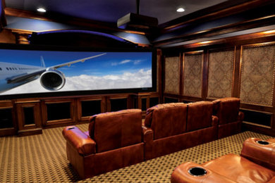 Diseño de cine en casa cerrado de tamaño medio con paredes marrones, moqueta y pantalla de proyección
