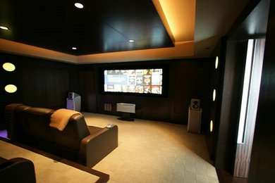 Ejemplo de cine en casa cerrado minimalista de tamaño medio con paredes negras, moqueta y pantalla de proyección