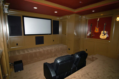 Ejemplo de cine en casa cerrado tradicional grande con paredes beige, moqueta y televisor colgado en la pared