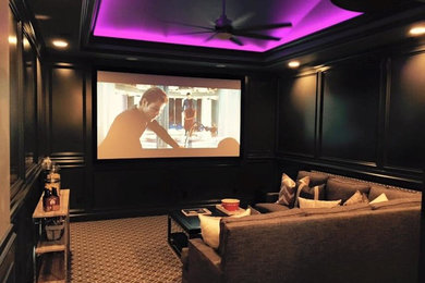Cette photo montre une salle de cinéma chic de taille moyenne et fermée avec un mur marron, moquette, un écran de projection et un sol marron.