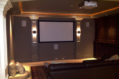 Modelo de cine en casa cerrado con paredes beige, moqueta y pantalla de proyección