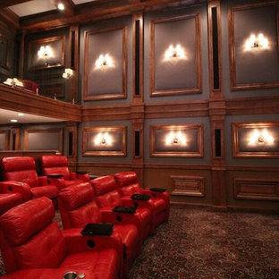Cette image montre une grand salle de cinéma fermée avec un mur multicolore, moquette, un écran de projection et un sol multicolore.