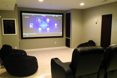 Imagen de cine en casa cerrado tradicional de tamaño medio con moqueta, pantalla de proyección y paredes grises