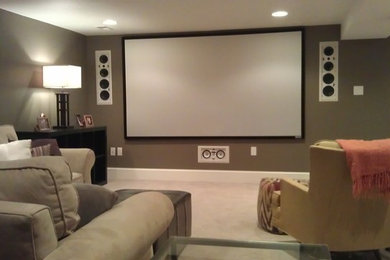 Modelo de cine en casa abierto clásico grande con paredes marrones, moqueta, pantalla de proyección y suelo beige