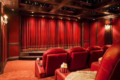 Modelo de cine en casa cerrado tradicional extra grande con paredes rojas, moqueta y pantalla de proyección