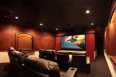 Modelo de cine en casa cerrado clásico grande con paredes multicolor, moqueta y pantalla de proyección