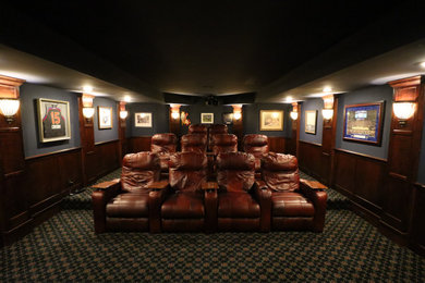 Foto de cine en casa cerrado tradicional grande con paredes azules, moqueta, pantalla de proyección y suelo negro