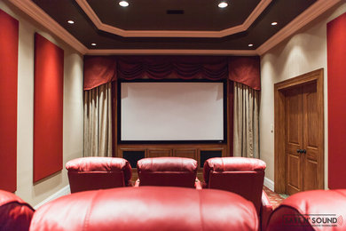 This is an example of a medium sized classic enclosed home cinema in Other with beige walls, carpet and a projector screen.