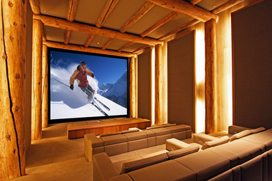 Home theater - rustic enclosed carpeted and beige floor home theater idea in Denver with brown walls and a projector screen