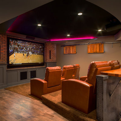 Elegant medium tone wood floor and brown floor home theater photo in Kansas City with brown walls