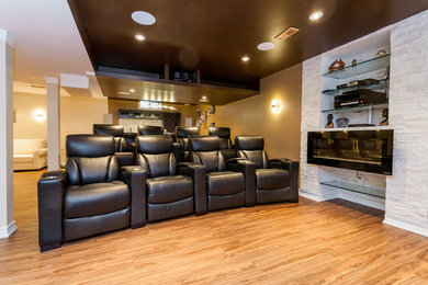 Example of a mid-sized transitional enclosed light wood floor and brown floor home theater design in Toronto with beige walls and a projector screen
