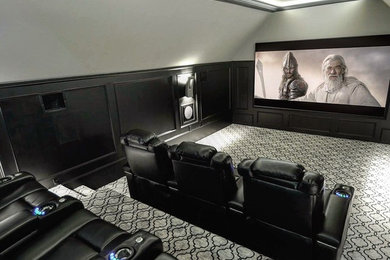 Modelo de cine en casa cerrado contemporáneo con paredes grises, moqueta y pantalla de proyección