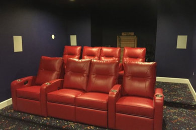 Inspiration for a mid-sized open concept carpeted home theater remodel in DC Metro with purple walls and a media wall