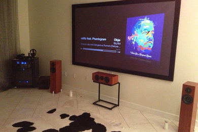 Example of a large eclectic ceramic tile home theater design in Miami with beige walls and a wall-mounted tv