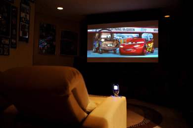 Home theater - large traditional enclosed carpeted home theater idea in Other with a projector screen