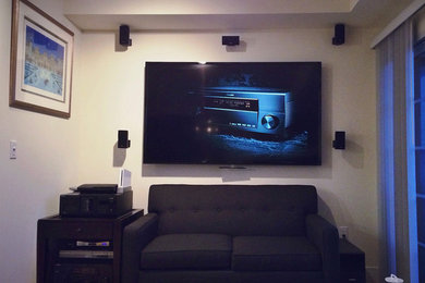 Diseño de cine en casa moderno con paredes beige y televisor colgado en la pared