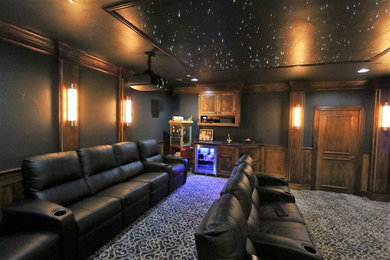 Home theater - large traditional enclosed carpeted home theater idea in Dallas with black walls and a projector screen