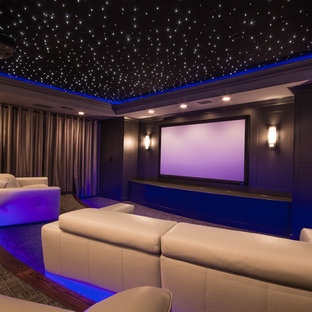 Large trendy enclosed carpeted and gray floor home theater photo in Atlanta with gray walls and a projector screen