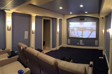 Foto di un home theatre tradizionale di medie dimensioni e chiuso con pareti viola, moquette, schermo di proiezione e pavimento nero