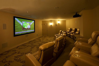 Example of a large trendy enclosed carpeted and beige floor home theater design in Chicago with beige walls and a projector screen