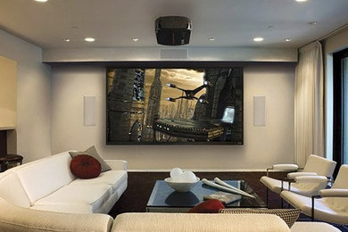 Diseño de cine en casa cerrado moderno grande con paredes beige, suelo de madera oscura, pantalla de proyección y suelo marrón