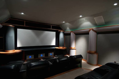 Cette photo montre une salle de cinéma chic fermée avec un mur gris, moquette et un téléviseur fixé au mur.