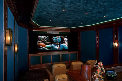 Ejemplo de cine en casa cerrado grande con paredes azules, moqueta y pantalla de proyección